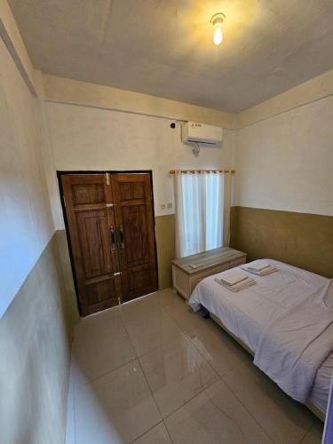 a small bedroom with a bed and a window at Cemara Paradise Homestay in Pulau Gilimelayu