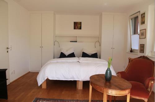 a bedroom with a bed and a table and a chair at Zimmer am Ring - ruhiges Zimmer im Grünen, Frühstück auf eigener Terrasse mit Morgensonne und fußläufig zum Badeplatz Schwarzindien am Mondsee in Sankt Lorenz