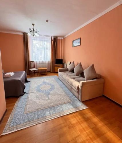 a living room with a couch and a bed at Hotel Nurlytau in Borovoye