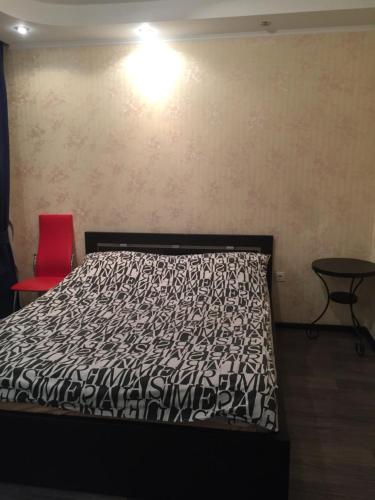 ナーベレジヌイェ・チェルヌイにあるApartments on Adelya Kutuya 3のベッドルーム1室(ベッド1台、赤い椅子付)
