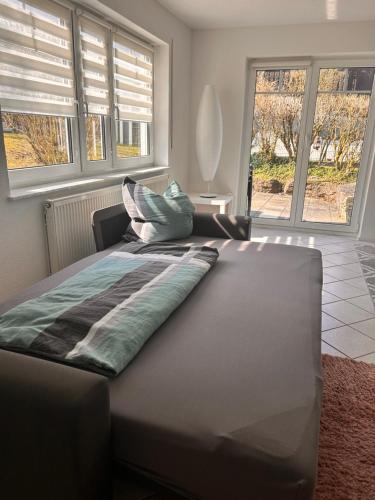 a bed in a room with a large window at Ferienwohnung Schwarzwaldrand in Nagold