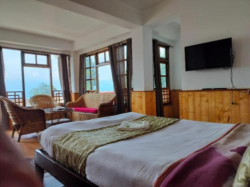 a bedroom with a bed and a flat screen tv at Hotel Kabur in Pelling