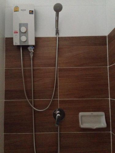 a shower with a hose attached to a wall at Baan Khao Yai Condo in Mu Si