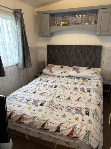a bed in a bedroom with a bedspread with trains on it at Haven Caravan Park Cala Gran 3 bedrooms Fleetwood in Fleetwood