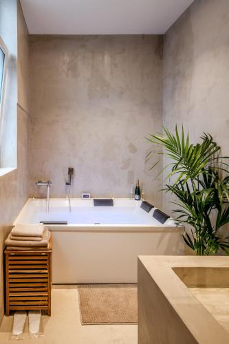 a bath tub in a bathroom with a plant at La parenthèse lilloise in Lille