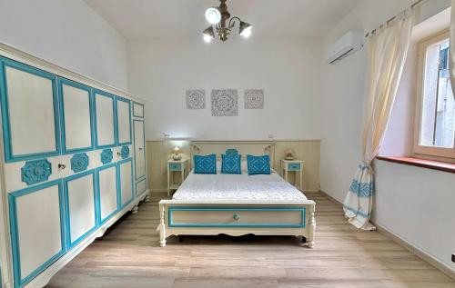 a bedroom with a bed with blue pillows at Casa vacanze Nuraghe Orosei in Orosei