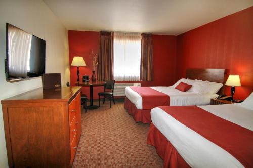 a hotel room with two beds and a flat screen tv at Pahrump Nugget Hotel & Casino in Pahrump