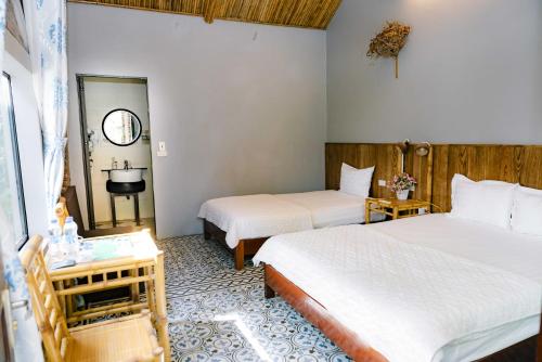 a hotel room with two beds and a sink at The Hive Homestay - Tam Coc in Ninh Binh