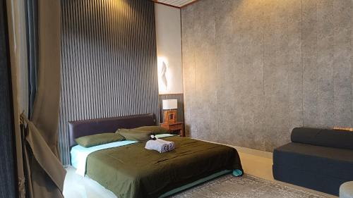 a bedroom with a bed with a stuffed animal on it at Nyoman Guest House in Singaraja