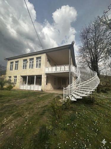 a building with a white staircase in front of it at Guest hous Tamuna in Martvili