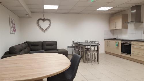 - un salon avec une table et un cœur sur le mur dans l'établissement Gite grand format, à Colmar