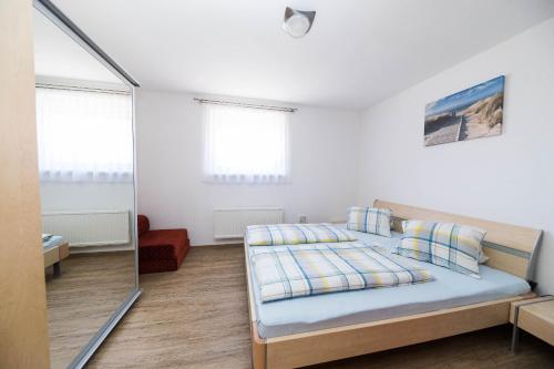 a white bedroom with a bed and a mirror at Apartment Dea 3 Spacious Lower-Level Apartment in Crikvenica