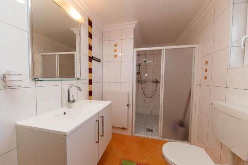 a white bathroom with a sink and a shower at Apartment Dea 3 Spacious Lower-Level Apartment in Crikvenica