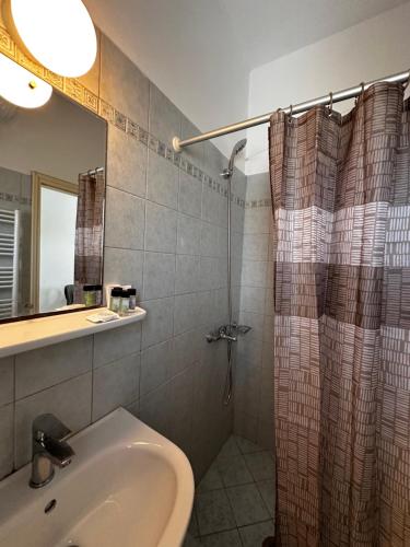 a bathroom with a shower curtain and a sink at Elia II in Kondoliánika