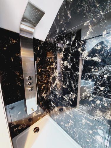 a bathroom with a black and white marble wall at Villa VIP in Welkenraedt