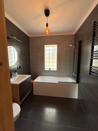 a bathroom with a tub and a toilet and a sink at Leśna Polana in Józefów
