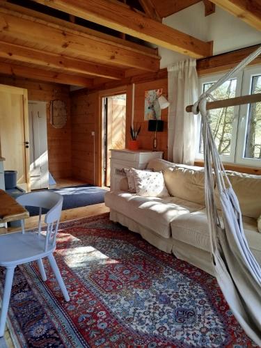ein Wohnzimmer mit Sofa und Hängematte in der Unterkunft Ulęgałki Roztocze in AdamÃ³w
