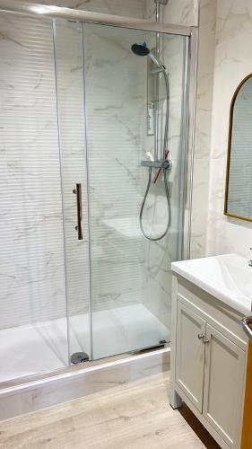 a shower with a glass door in a bathroom at Little Gem in Swanage