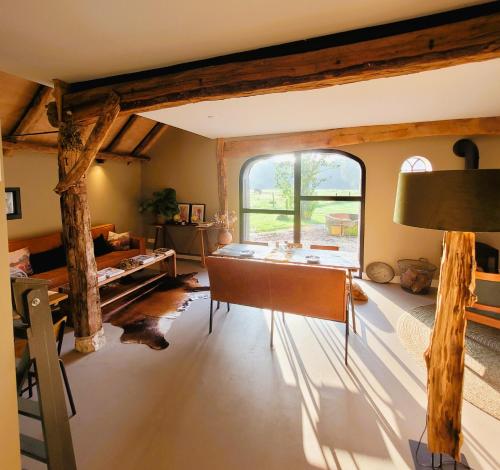 a living room with a table and a large window at 't Buitenverblijf Erve Punte in Losser