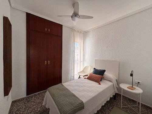 a bedroom with a bed and a table and a ceiling fan at Mediterranean House in Valencia in Valencia