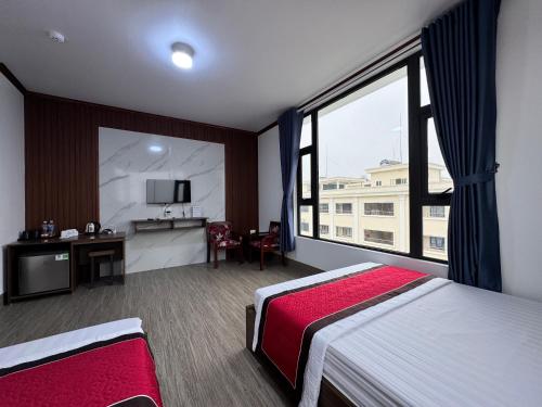 a hotel room with two beds and a large window at Xuan Thanh Hotel in Thanh Hóa