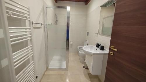 a white bathroom with a toilet and a sink at Casa Cappuccini in Comacchio