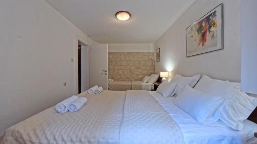 a bedroom with a large white bed with towels on it at Old Town Stay by Ivo in Trogir