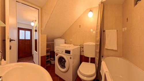 a bathroom with a toilet a sink and a washing machine at Old Town Stay by Ivo in Trogir