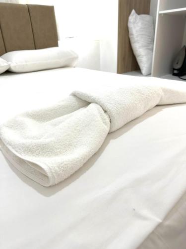 a pair of white towels sitting on a bed at Taku Rooms Vlora in Vlorë