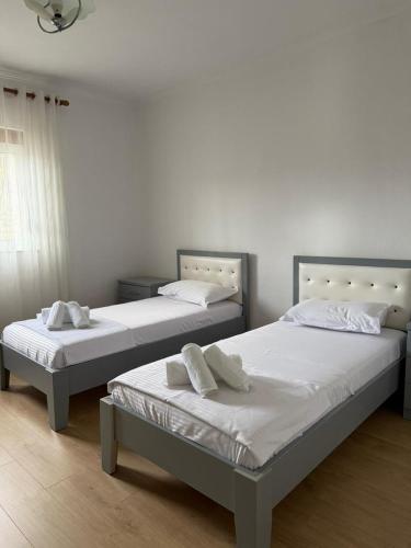 two beds sitting next to each other in a bedroom at Marl's Home in Berat