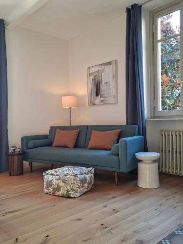a living room with a blue couch and a table at Villa Grappoli Apt MAGGIORE with lake view in Lesa