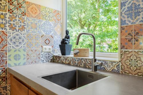 a kitchen with a sink and a window at Vakantiepark De Kremmer in Gasselte