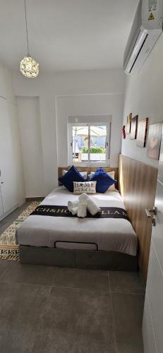 a bedroom with a large bed with blue pillows at Beach & House''Villa Maria'' 5 min to Mareta Beach in Sagres