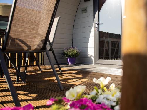 a rocking chair on a porch with flowers at Skylark - Pod in Northrepps
