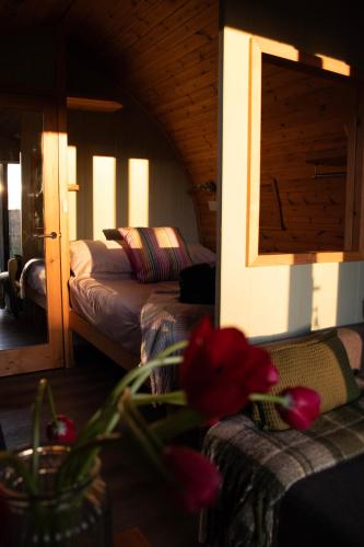 a bedroom with two beds and a vase with a flower at Skylark - Pod in Northrepps