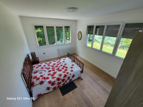 a bedroom with a bed with a red flowered blanket at La Maison Bloom in Houilles