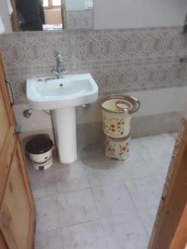 a bathroom with a sink and a toilet at Maharani Garden in Haldwāni