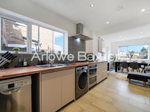 a kitchen with a sink and a dishwasher at Watford Large 5BR Home - Contractors & Families in Watford