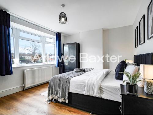 a bedroom with a large bed and a window at Watford Large 5BR Home - Contractors & Families in Watford