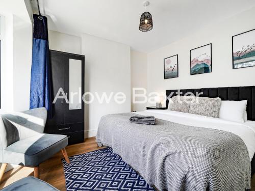 a bedroom with a bed and a chair at Watford Large 5BR Home - Contractors & Families in Watford