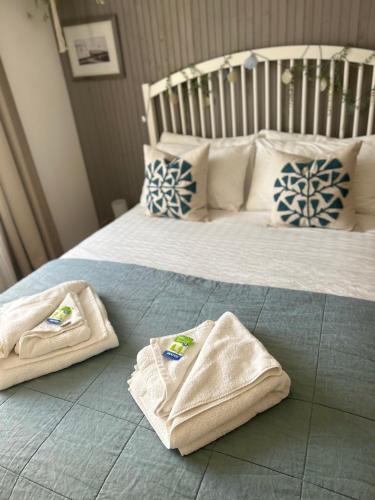 two towels sitting on top of a bed at Little Gem in Swanage