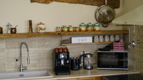 a kitchen counter with a sink and a microwave at Happy Tuscany in Rigomagno