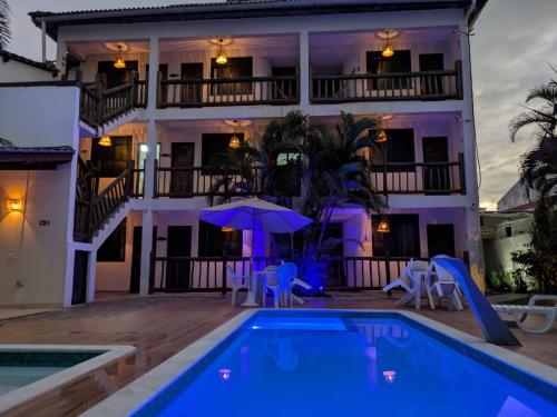 a villa with a swimming pool in front of a building at Pousada Stella Tropical in Salvador