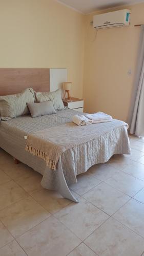 a bedroom with a large bed with a blanket on it at Once Reinas Departamentos in San Rafael