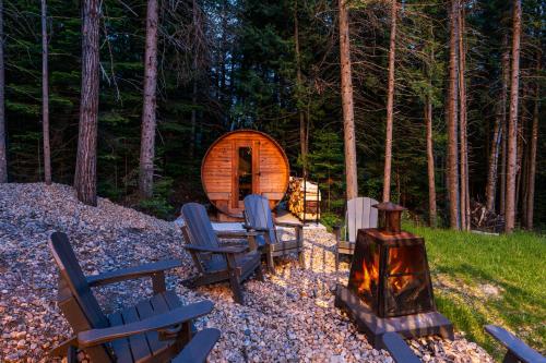 a group of chairs and a fireplace in front of a cabin at Villa Forêsta Ski, Spa & Sauna in Saint Come