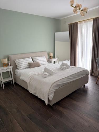 a bedroom with a large bed with two towels on it at Perlina Naxxar in Naxxar