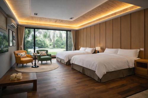 a hotel room with two beds and a table and chairs at Greenfield Villa in Fengping