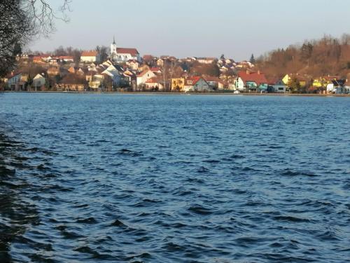 a large body of water with a town in the background at Chata Roubenka in Jedovnice