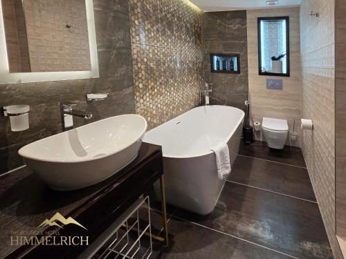 a bathroom with a tub and a sink and a toilet at Boutique Hotel Himmelrich in Lucerne