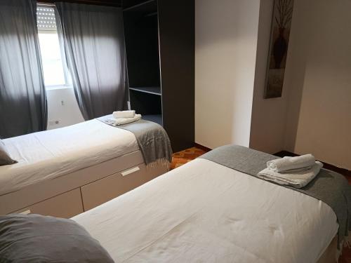 a bedroom with two beds and a window at A Ribeira in Fene